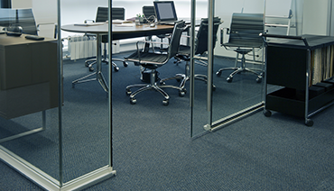 Image of office with glass walls and rolling chairs at informal desk